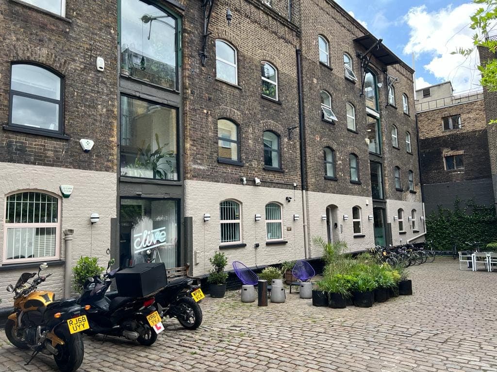 Axe & Bottle Court: a converted Victorian brick warehouse around a cobbled courtyard, with planters and bikes outside.