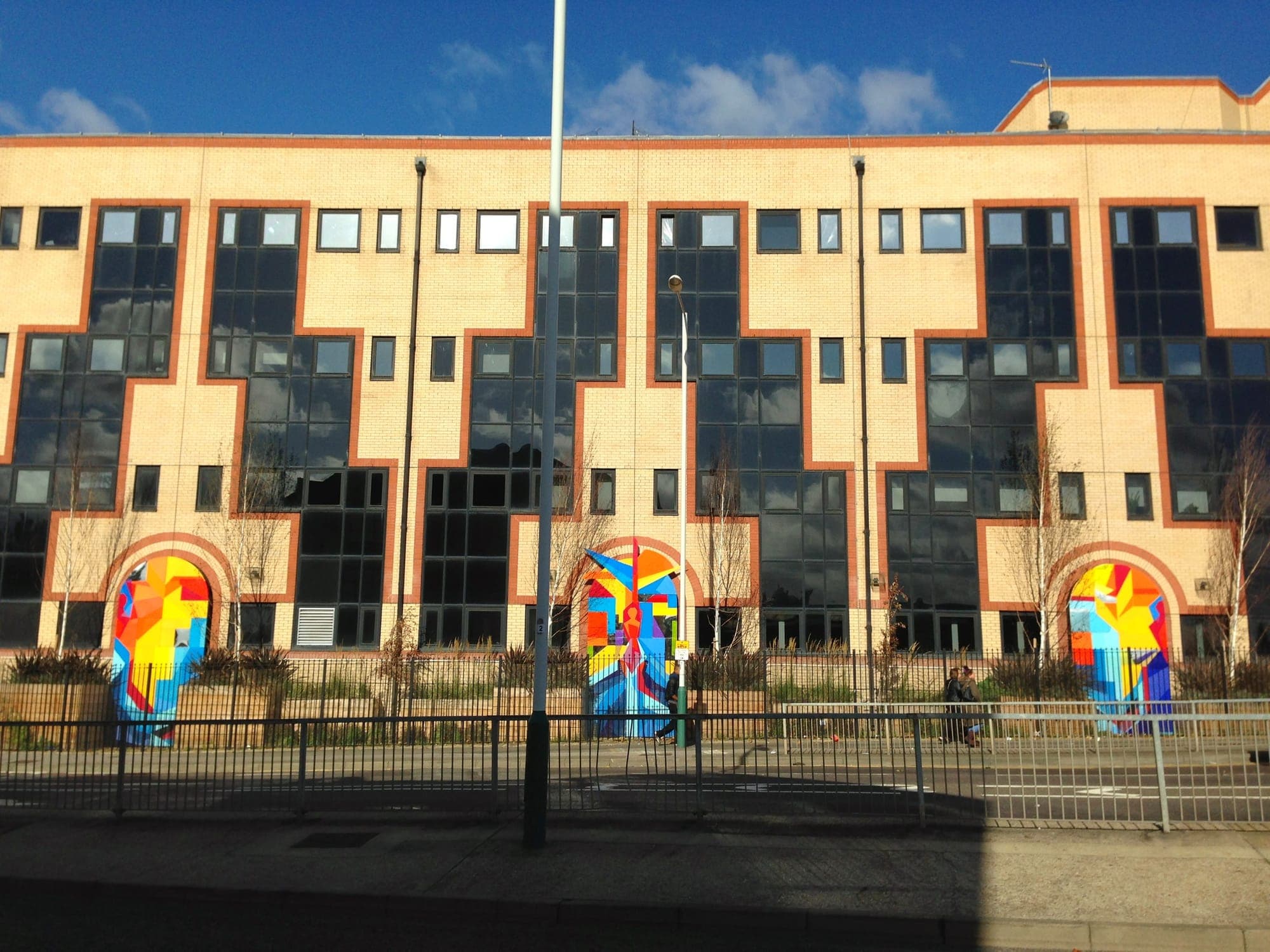 210 South Street: a four-storey buff brick office block with red brick window surrounds and painted murals in the ground-floor arches.